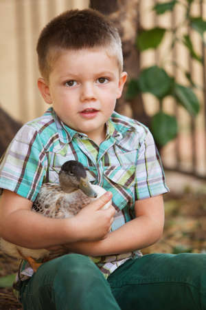 Single smiling child holding a duck outdoorsの写真素材