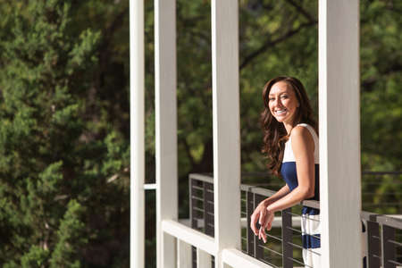 Single female adult standing on balcony outdoorsの写真素材