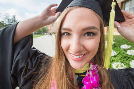 Energetic Caucasian female college student with cap outdoorsの写真素材