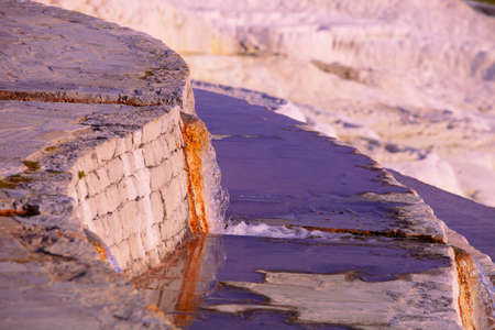 Hot mineral spring water pouring from notch in wall at Pamukkale in Turkeyの写真素材