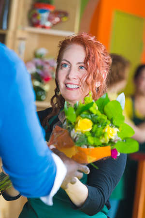 Woman selling bouquet in a busy flower shopの写真素材