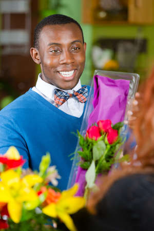 Handsome man purchasing roses at a florist shopの写真素材