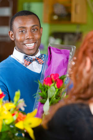 Dapper man purchasing roses at a florist shopの写真素材