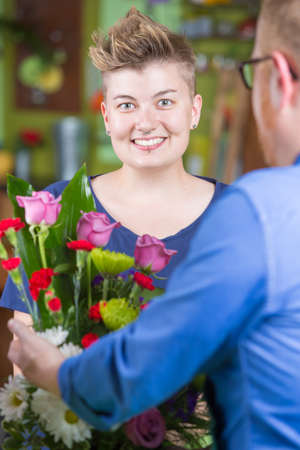 Smiling woman buying arrangement at a florist shopの写真素材