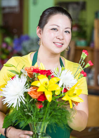Beautiful young woman creating a floral arrangementの写真素材