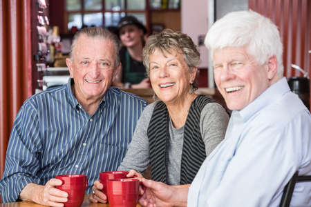 Three happy friends in a coffee houseの写真素材