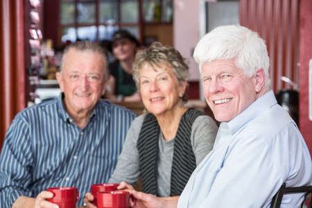 Man with two mature friends in a coffee houseの写真素材