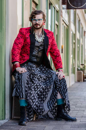 Gender fluid young man in boots and skirtの写真素材