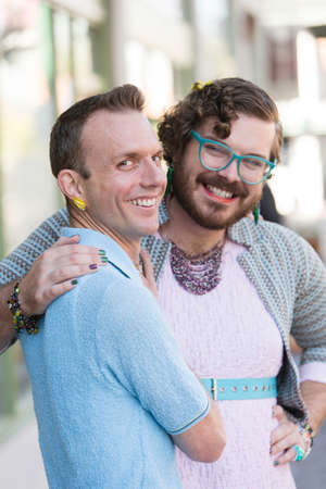 Gender fluid young male couple embracing on urban streetの写真素材