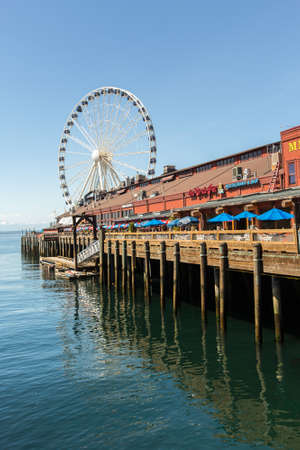 SEATTLE, WA - MAY 12: Businesses with ferris wheel in background on Seattleâs waterfront. May 12, 2016 in Phoenix, AZ.のeditorial素材