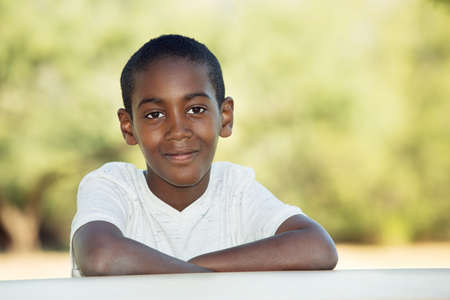 Cute male child seated at table with copy space to his sideの写真素材