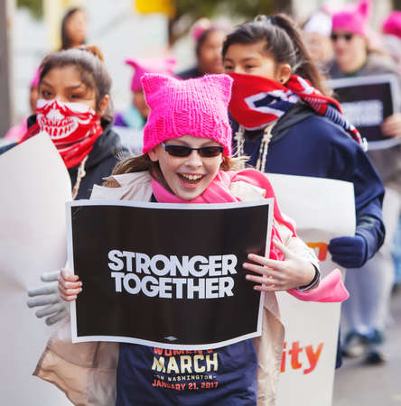 TUCSON, AZ - JANUARY 21: Happy trio of white and Latina girls holding protest signs at Women's March on Washington January 21, 2017 in Tucson, AZ, USA.のeditorial素材