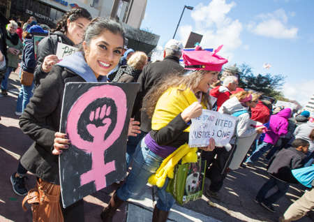 TUCSON, AZ - JANUARY 21: Happy teen female holding pink fist symbol sign at the Women's March on Washington January 21, 2017 in Tucson, AZ, USA.のeditorial素材