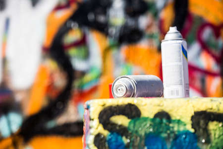 Used paint cans near a wall with graffitiの写真素材