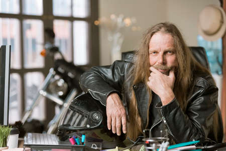 Serious man in his office with a motorcycleの写真素材