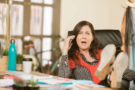 Professional woman reacting to negative phone conversationの写真素材