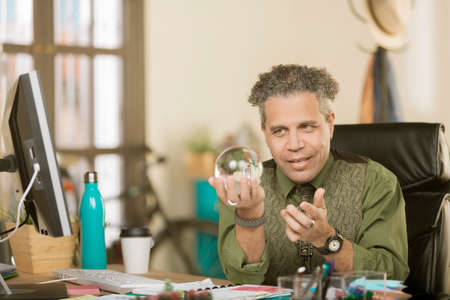 Confident creative professional man with a crystal ballの写真素材