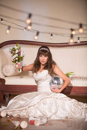Unhappy bride wielding her wedding bouquetの写真素材