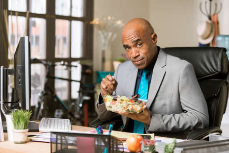 Professional man having a healthy lunch in his officeの写真素材