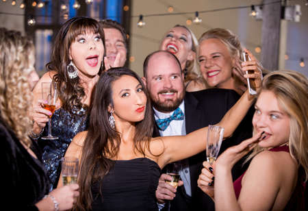 Pretty woman taking a party selfie with friendsの写真素材