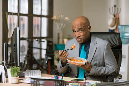 Professional man not enjoying a quick lunchの写真素材