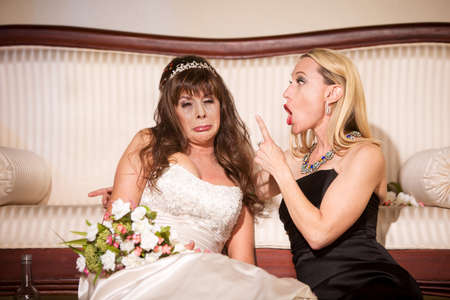 Friend shaming sad bride at a weddingの写真素材