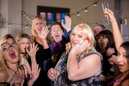 Trans woman at a party with enthusiastic friendsの写真素材