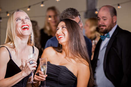 Two pretty women laughing at a couple of menの写真素材