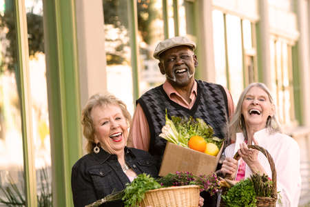 Laughing seniors returning with groceries from farmers marketの写真素材