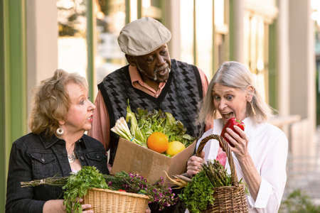 Three seniors with groceries from farmers marketの写真素材