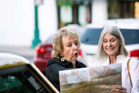 Two women in a city center checking road mapの写真素材