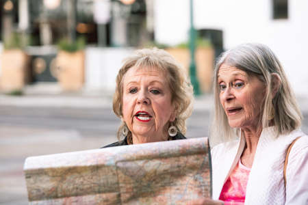 Two women in a city center checking road mapの写真素材