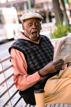 Man downtown with newspaper reacts to storyの写真素材