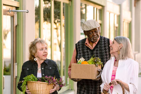Smiling seniors returning with groceries from farmers marketの写真素材