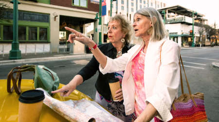Two women in a city center with a road mapの写真素材