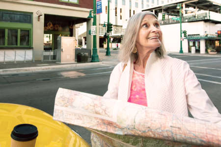 Woman in a city center with a holding road mapの写真素材