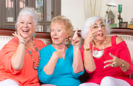 Three senior ladies in bright colored clothes vamping and posingの写真素材
