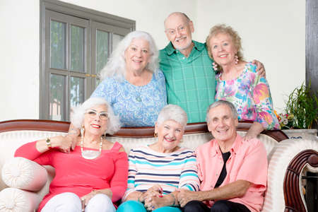 Six senior friends around an antique couchの写真素材