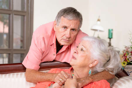 Worried senior man and woman at homeの写真素材