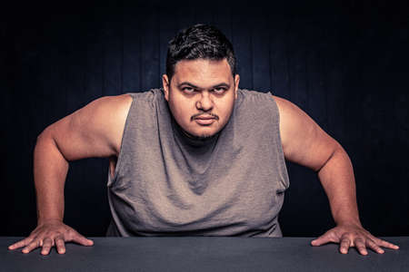 Angry Latino man with arms bared leaning inの写真素材