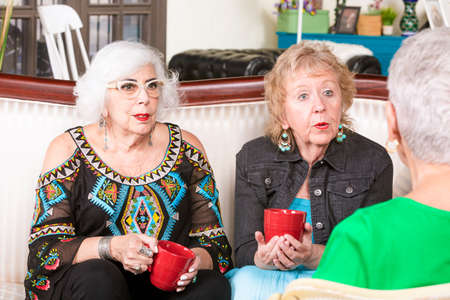 Three senior women enjoying a coffee or tea togetherの写真素材