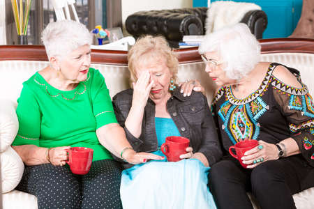Two senior women support their upset friendの写真素材