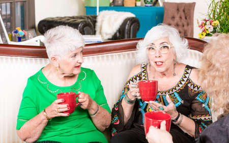 Three senior sharing having a coffee or tea togetherの写真素材