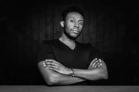 Black and white handsome man in a powerful pose with arms crossedの写真素材