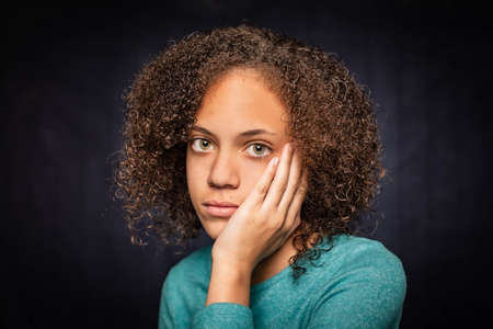 Sad young woman with her head resting on a handの写真素材