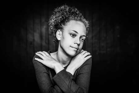 Black and white pretty young girl seated with thoughtful expressionの写真素材