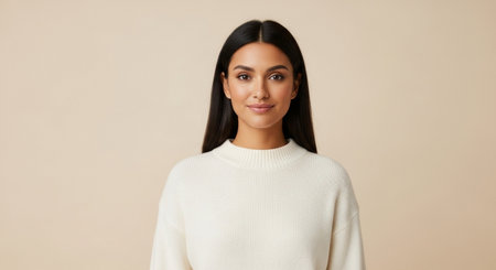 Portrait of a beautiful young woman in a white sweater on a beige backgroundの素材