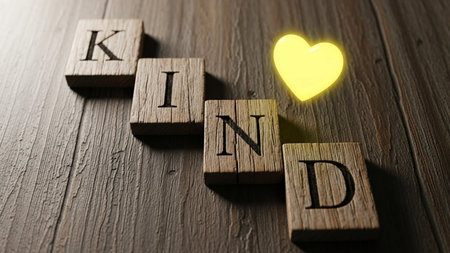 The word KIND made of wooden blocks and a yellow heart.の素材