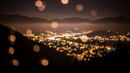 Blurred bokeh of city lights in the mountains at nightの素材