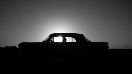 Abandoned car in the desert at sunset. Black and white photo.の素材